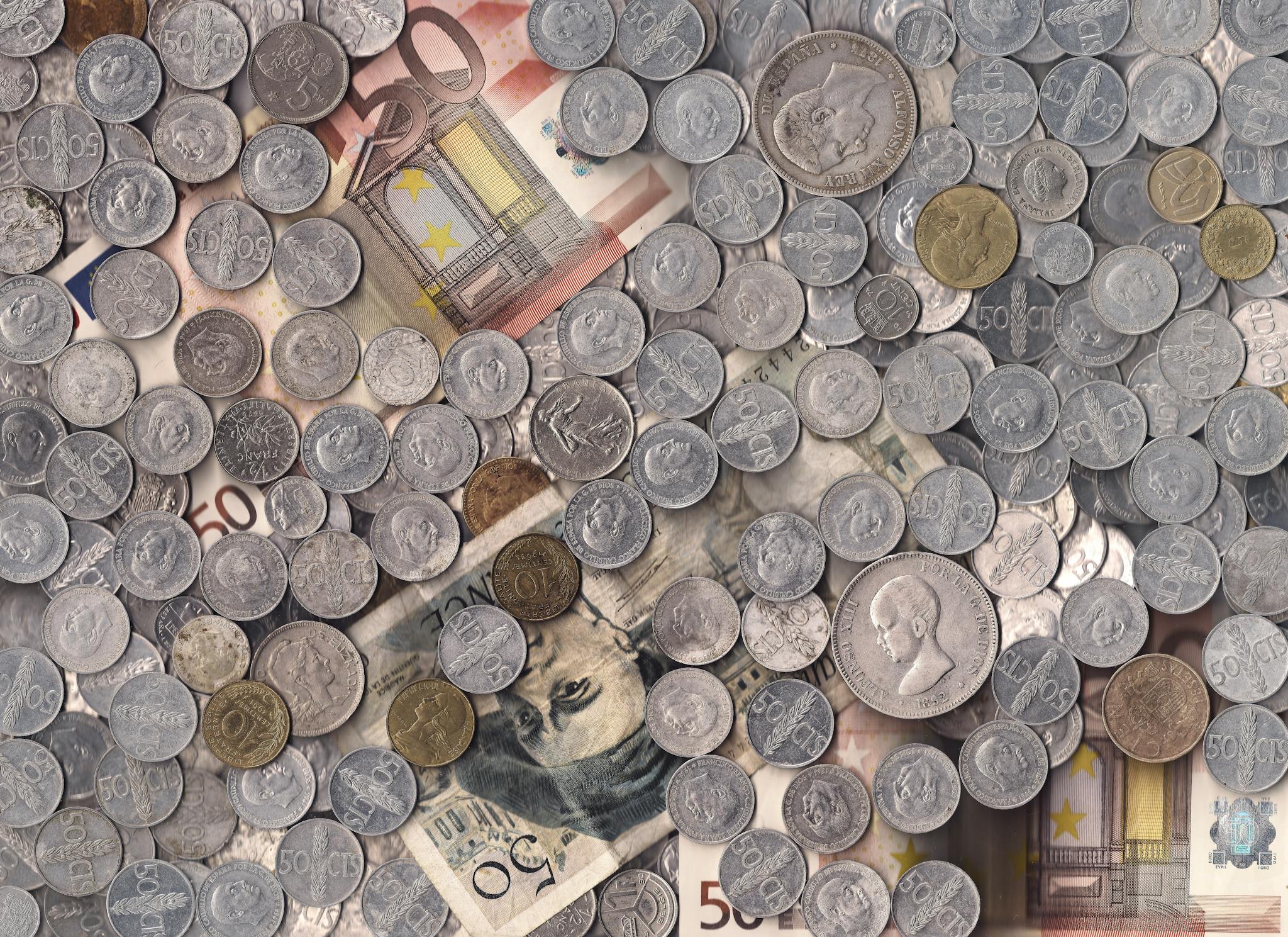 A collection of various European currency coins and notes in a scattered arrangement.