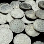 Close-up of Ukrainian Hryvnia coins scattered against a dark background, showing detailed engravings.